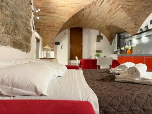 a bedroom with a large bed with white pillows at Charming Studio with Brick Vaulted Ceilings in Perugia