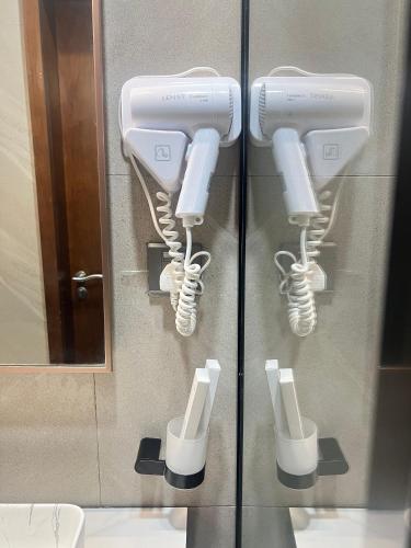 a bathroom with multiple hair dryers on a wall at Zabibu Hotel in Dodoma