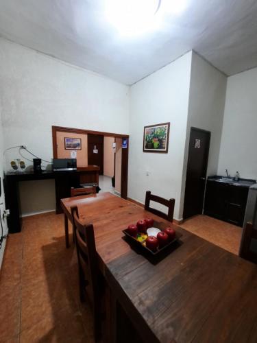 a dining room with a wooden table with fruit on it at Garcia's Suites y Hotel Villegas in Linares