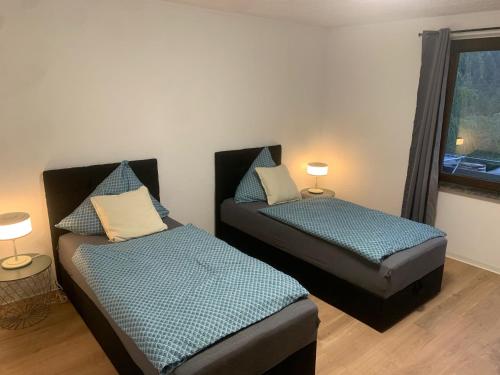 two twin beds in a room with a window at Ferienwohnung Schimpf in Sosberg
