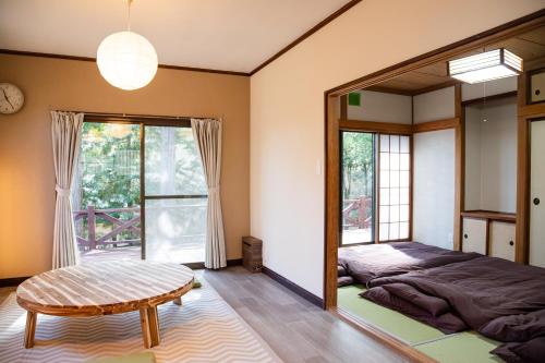 a bedroom with a mirror and a bed and a table at -貸切別荘-源泉かけ流し温泉 あずみ野ガレージヴィラ-1日1組限定- in Azumino