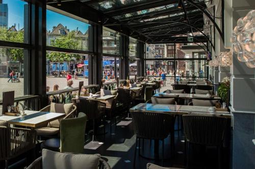 a restaurant with tables and chairs and a view of a street at Golden Tulip Hotel Central in Den Bosch