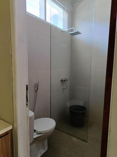 a bathroom with a toilet and a glass shower at Uciek Tengger Hotel Bromo in Ngadisari