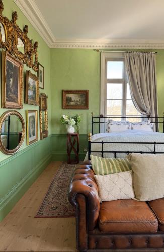 a bedroom with a bed and a leather couch at Hoby Kulle Herrgård B&B in Bräkne-Hoby
