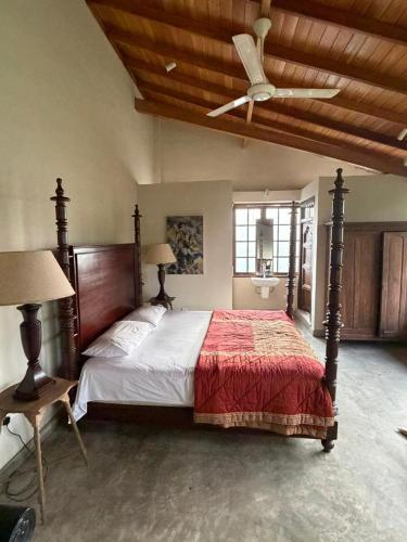 a bedroom with a bed and a ceiling fan at Weaver Bird Residencies in Hewagama
