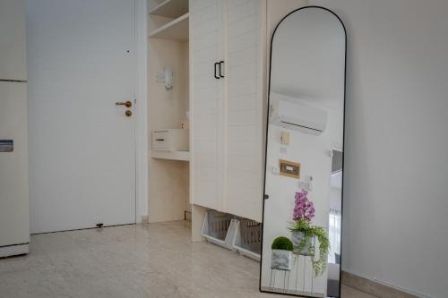 a mirror in a room with a kitchen at Aphrodite Limassol Apartment in Limassol