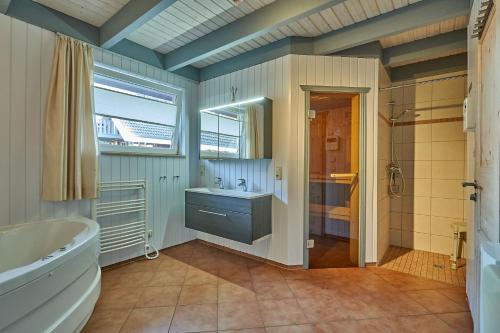 a bathroom with a tub and a sink and a shower at Wildgans Classic 249 in Mirow