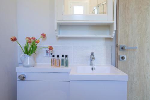a bathroom with a sink and a vase of flowers at Villa Avlaki in Vlikhón