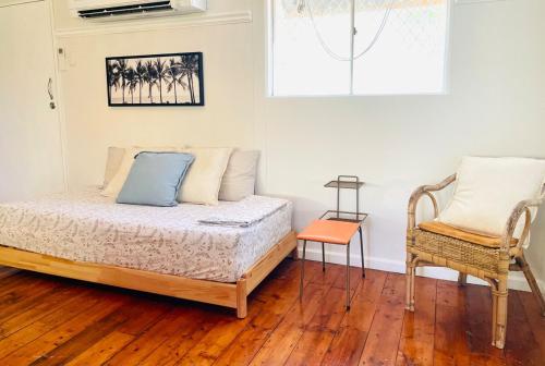 a bedroom with a bed and a chair at The Mango Shack in Carnarvon