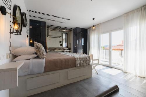a bedroom with a large bed and a large window at K Studios in Faliraki