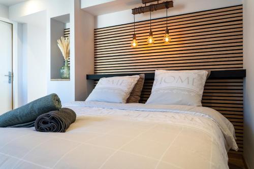 a bedroom with two beds and a large headboard at Cocon chaleureux proche Epinal Private parking in Uxegney
