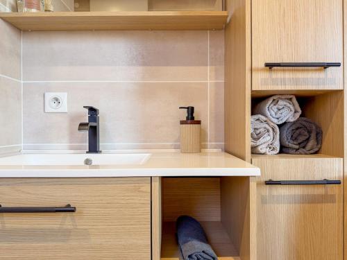 a bathroom with a sink and towels at Cocon chaleureux proche Epinal Private parking in Uxegney