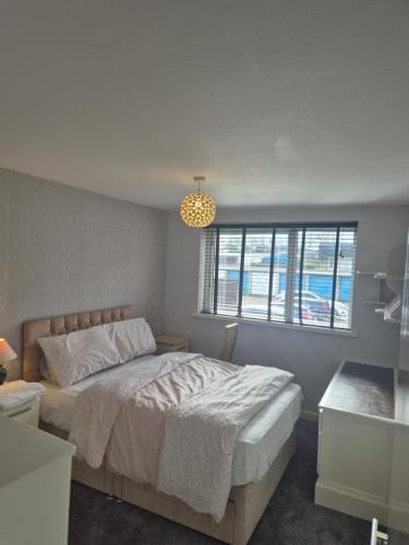 a bedroom with a large bed and a window at Three bedroom house with a garden in Redhill