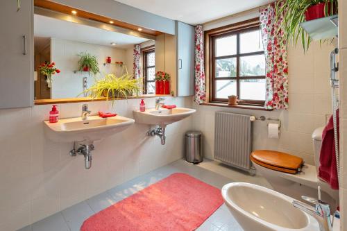 a bathroom with two sinks and a toilet and a mirror at Bed & Breakfast Hobro in Hobro