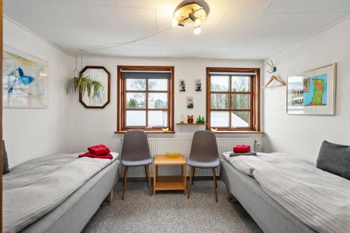two beds in a room with two chairs and a table at Bed & Breakfast Hobro in Hobro