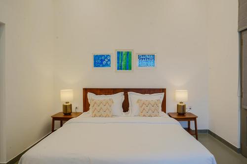 a bedroom with a large white bed with two tables at Eklektik in Colombo
