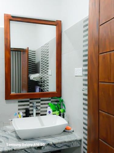 a bathroom with a white sink and a mirror at The Misty Crown in Hatton