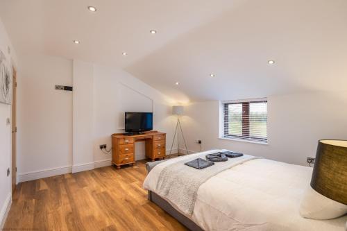 a bedroom with a bed and a tv on a dresser at Jenny's Barn - Sleeping 9, Dog friendly in Staveley