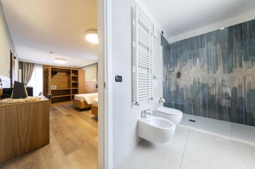 a bathroom with a sink and a toilet in a room at Family Hotel La Perla in Fiera di Primiero