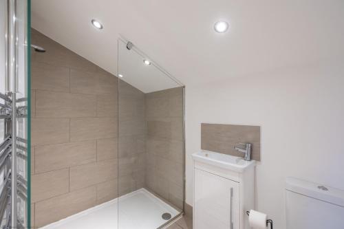 a bathroom with a shower with a toilet and a sink at Jenny's Barn - Sleeping 9, Dog friendly in Staveley