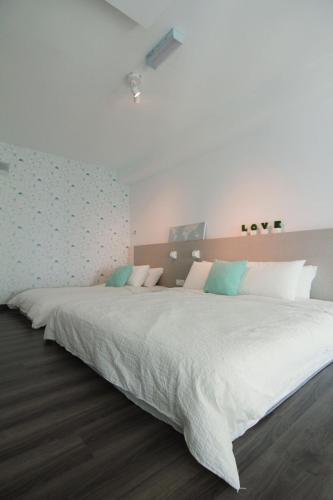 a bedroom with a large white bed with blue pillows at Maritime Full Seaview Duplex Suites in George Town
