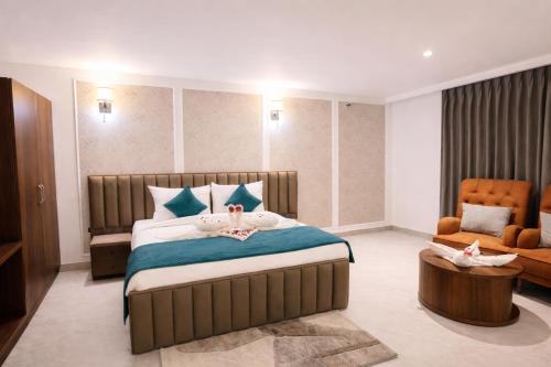a bedroom with a large bed and a chair at Tivoli Bijwasan in Jāmb