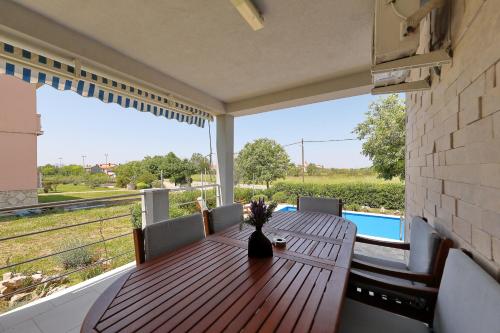 a wooden table on a porch with a view of a field at Eda in Vrsi