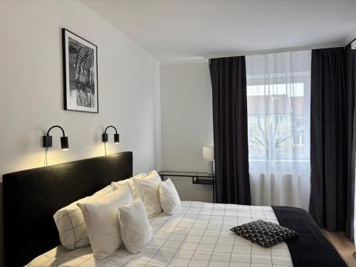 a bedroom with a bed with pillows and a window at Macropolis Apartments in Miskolc