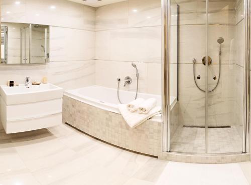 La salle de bains est pourvue d'une douche, d'une baignoire et d'un lavabo. dans l'établissement Rezidence Muzeum, à Prague