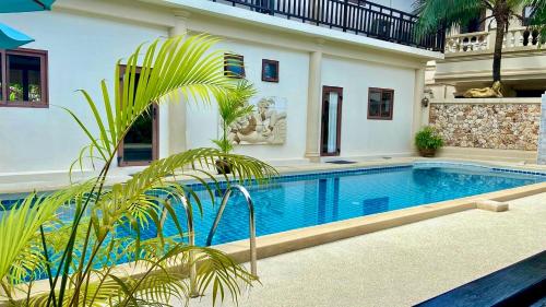 a house with a swimming pool in front of a house at Sibaja Palms Sunset Beach Luxury Villa in Taling Ngam Beach