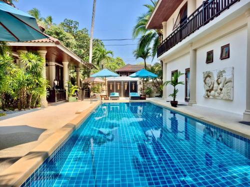 a swimming pool in a villa with a house at Sibaja Palms Sunset Beach Luxury Villa in Taling Ngam Beach