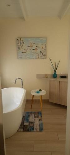 a bathroom with a white bath tub and a table at Deja Vu Cottage in Sedgefield
