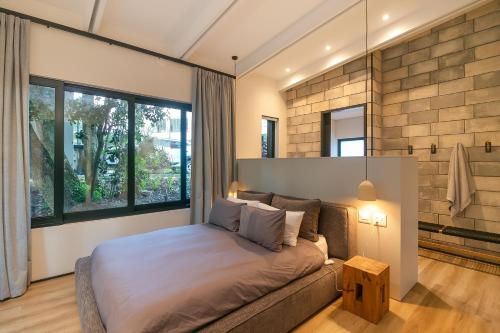 a bedroom with a bed and a couch and windows at Knysna Tsukamori in Knysna