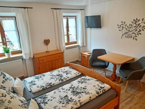 a bedroom with a bed and a desk and a table at Bauernhof Landsamer in Aschau im Chiemgau