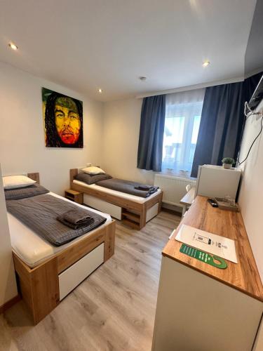 a room with two beds and a desk in it at RingRooms - Self Check-In in Knittelfeld