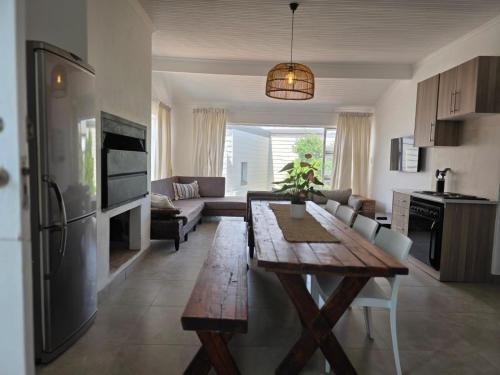 a kitchen and living room with a wooden table at Hartsepunt Seesig in Hartenbos