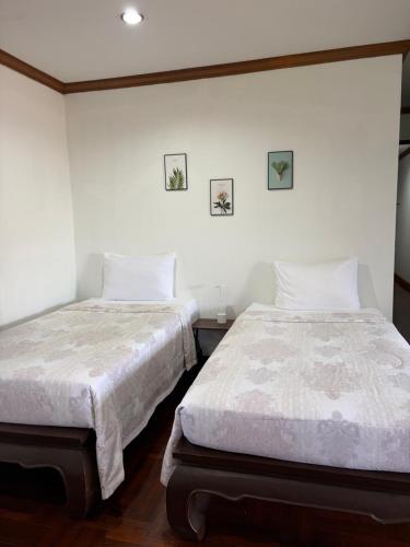 two beds sitting next to each other in a bedroom at Baan khunr home stay in Ban Bo Han