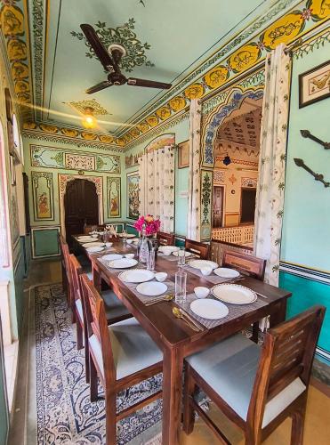 a dining room with a long table and chairs at Raj Haveli- A Heritage Samode in Jaipur