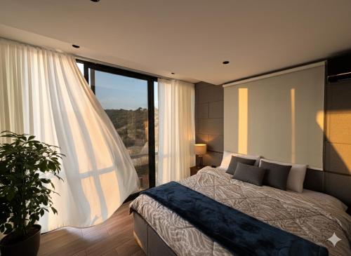 a bedroom with a bed and a large window at AlFahed Farm in Ajloun