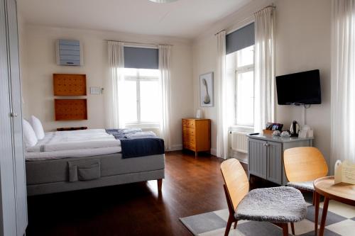 a bedroom with a bed and a tv in it at Sigtuna Stadshotell in Sigtuna