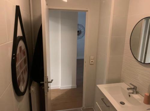 a bathroom with a sink and a mirror at Appartement moderne avec parking privé Lit connecté LED & rétroprojecteur 5 min Zénith in Saint-Herblain