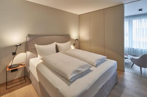 a bedroom with a large bed with white sheets and pillows at Michels Dependance des Hotel Misan in Norderney