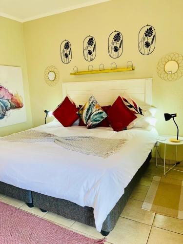 a bedroom with a large bed with red pillows at Wölfe Krantz Accommodation in Nelspruit