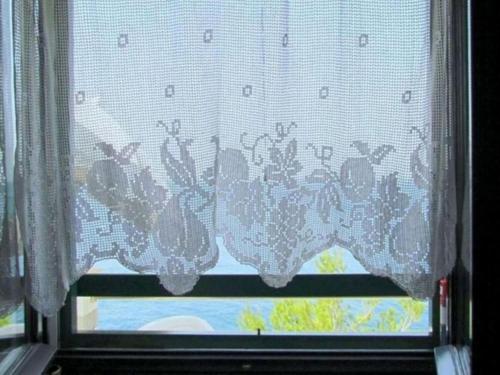 a window with a curtain with butterflies on it at Holiday house Jakov in Gdinj