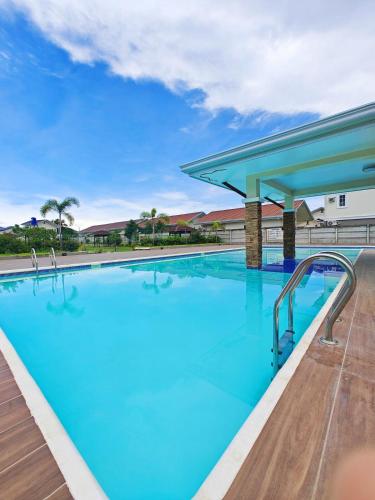 a large swimming pool with blue water at The Shores House-Royal Plams Tres by THE HOUSE in Dauis