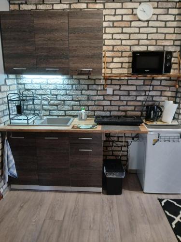 a kitchen with a sink and a brick wall at Noclegi nad Morzem u Kasi in Gdańsk