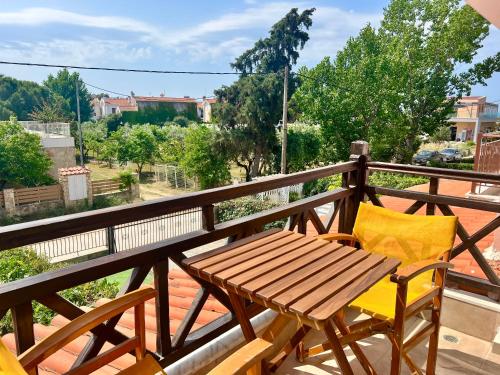 a wooden table and two chairs on a balcony at The SeaSide Villas in Nikiti