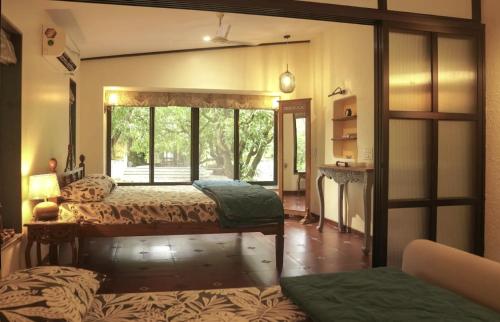 a bedroom with two beds and a window at The Rising Sun Farm Karjat - Luxury Stays - Couple Friendly in Karjat