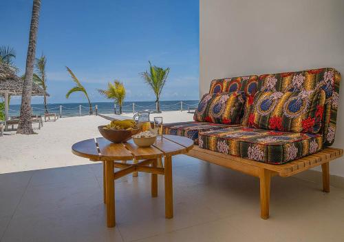 a living room with a couch and a table at Private Beach Front 2-Bedroom Apartment, Groundfloor in Kiwengwa
