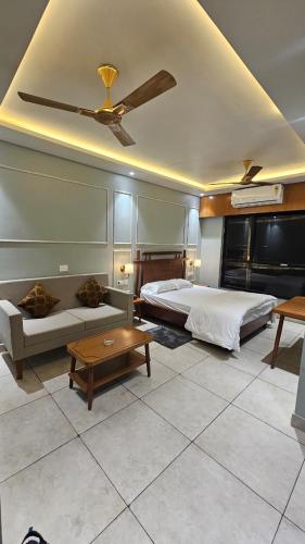 a bedroom with two beds and a table and a ceiling at Balaji Hotel and Resturant in Kolaghat
